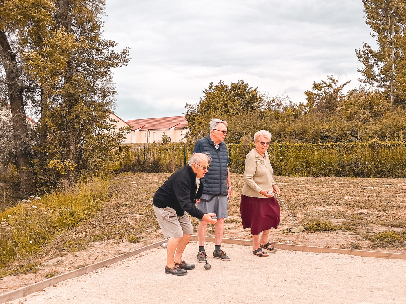 Résidents jouant à la pétanque sur le terrain du village Sérénya à Contres