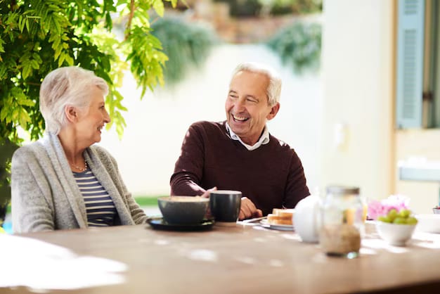 Couple de seniors souriants prenant le petit déjeuner en terrasse