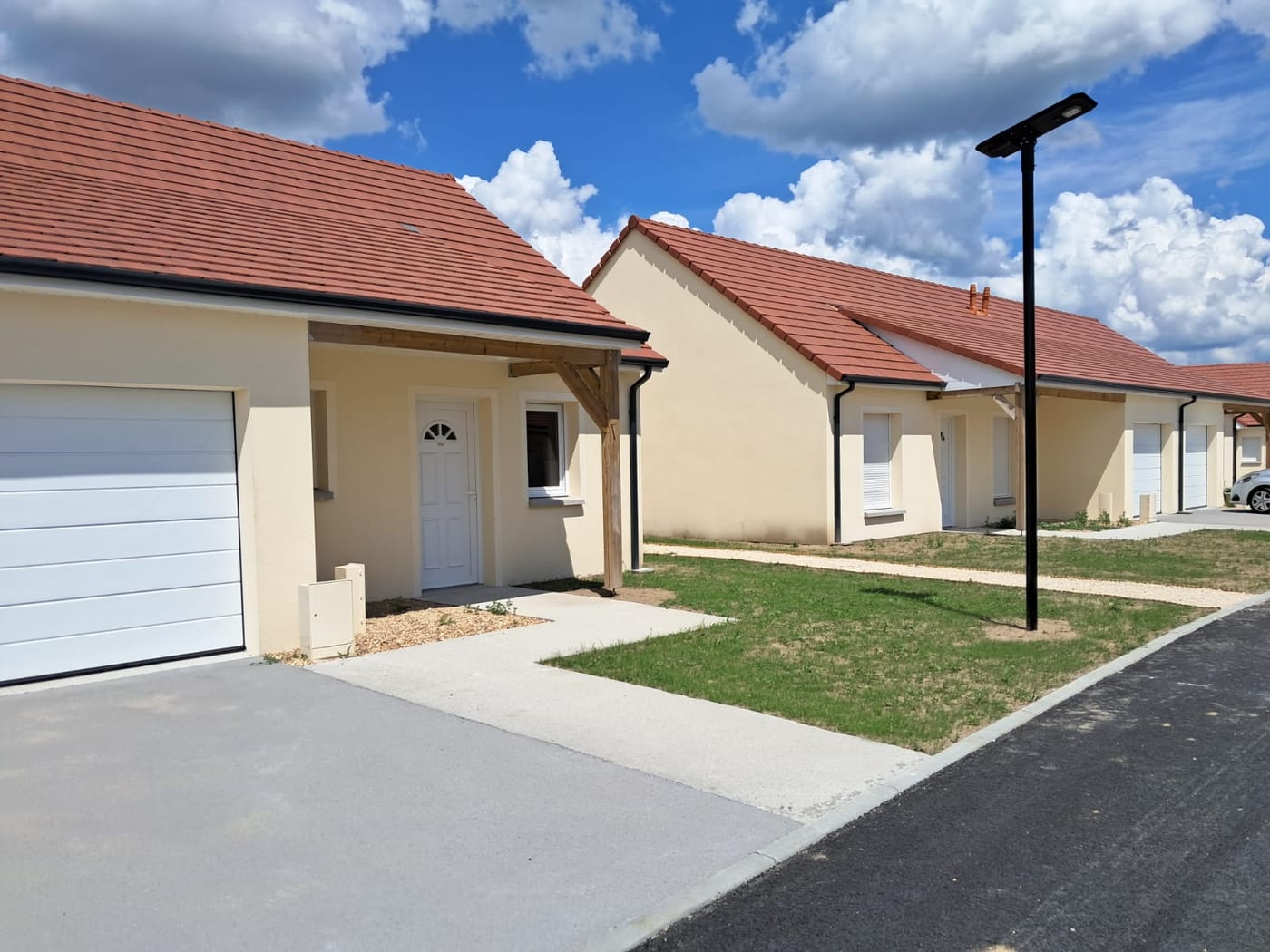 Rue du village Sérénya bordée de maisons de plain-pied avec garage